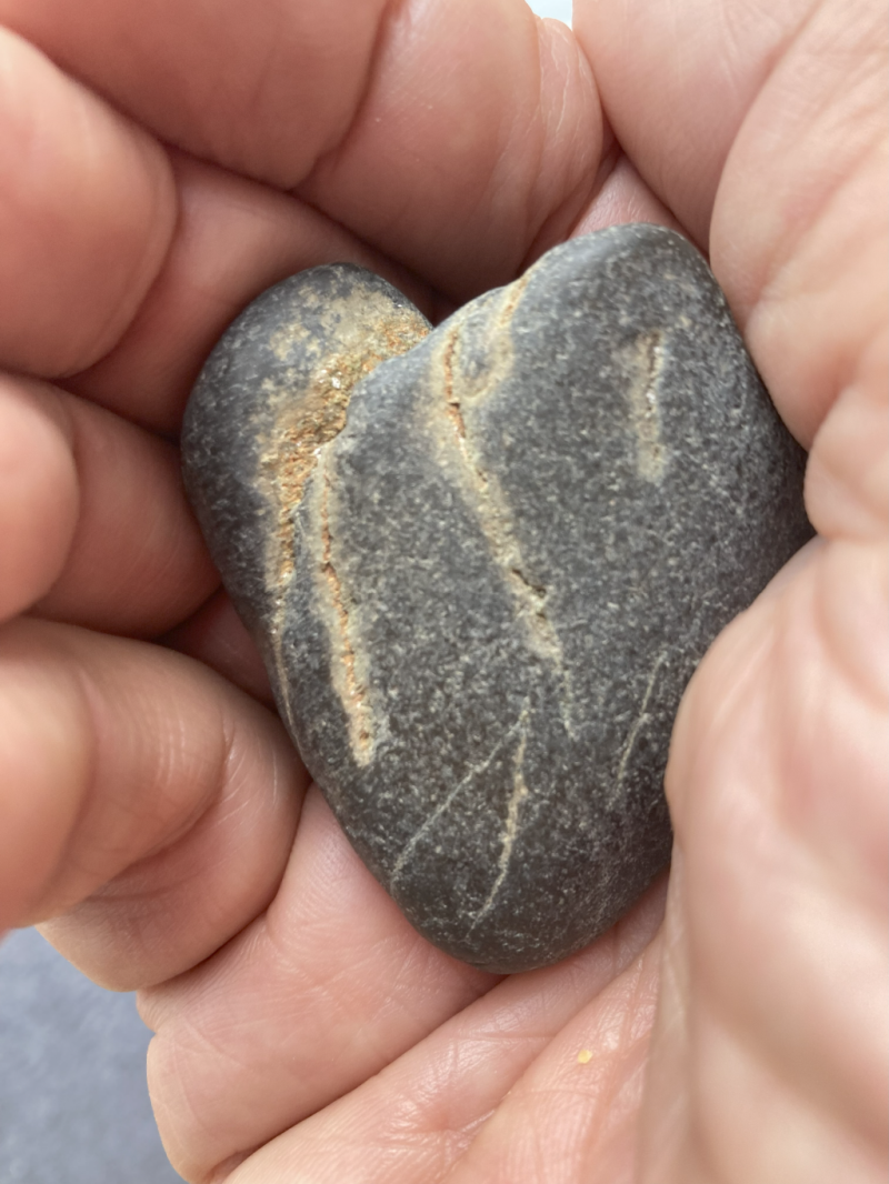Heart-shaped stone in the palm of a hand